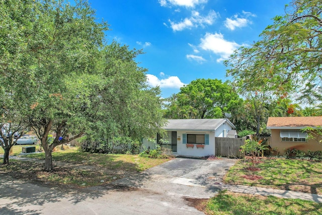 730 NE 23rd Pl, Pompano Beach, FL 33064 - view of front of house with fence, driveway, and stucco siding