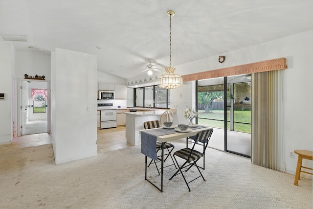 dining area featuring a ceiling fan, light carpet, and vaulted ceiling