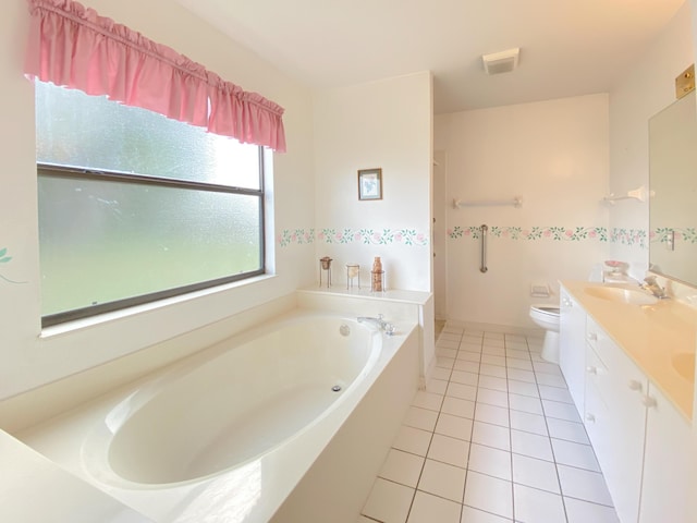 bathroom featuring tile patterned flooring, a bath, toilet, and double vanity