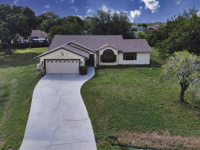 ranch-style home with driveway, a garage, a front lawn, and stucco siding