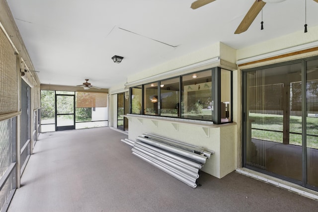 unfurnished sunroom with ceiling fan