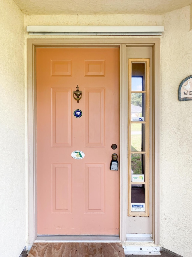 view of exterior entry with stucco siding