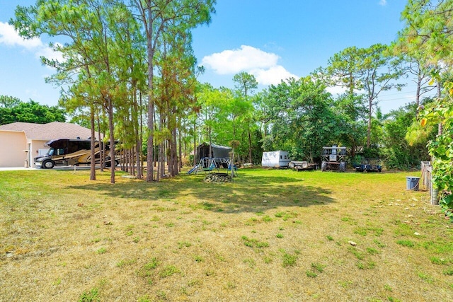 16737 Temple Blvd, Loxahatchee, FL 33470 - view of green lawn with a playground and view of scattered trees