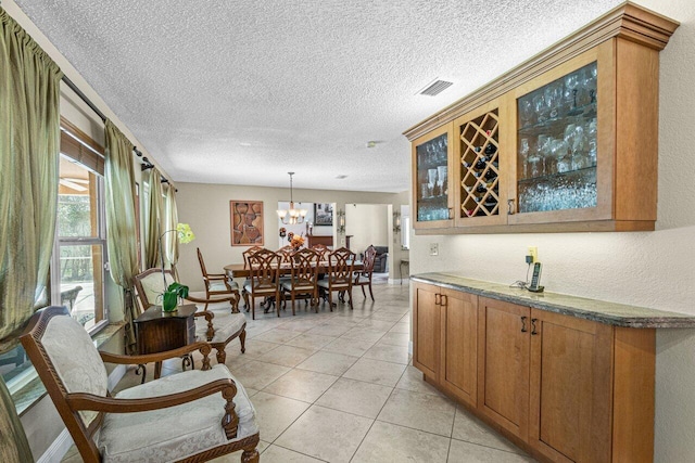 22075 Flower Dr, Boca Raton, FL 33428 - dining area with a textured ceiling, light tile patterned floors, bar, and a chandelier