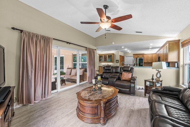 22075 Flower Dr, Boca Raton, FL 33428 - living room featuring lofted ceiling, a ceiling fan, light wood-style flooring, plenty of natural light, and a textured ceiling