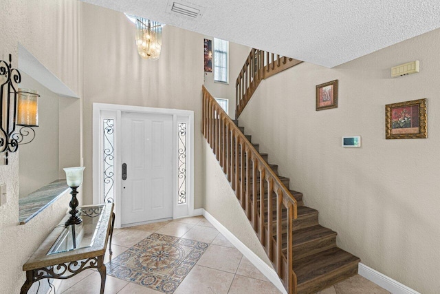 22075 Flower Dr, Boca Raton, FL 33428 - foyer featuring stairs, tile patterned flooring, baseboards, and a textured ceiling