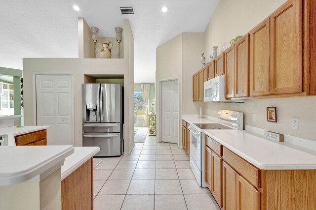 1985 SW Beard St, Port Saint Lucie, FL 34953 - kitchen with white appliances, light tile patterned floors, light countertops, and recessed lighting
