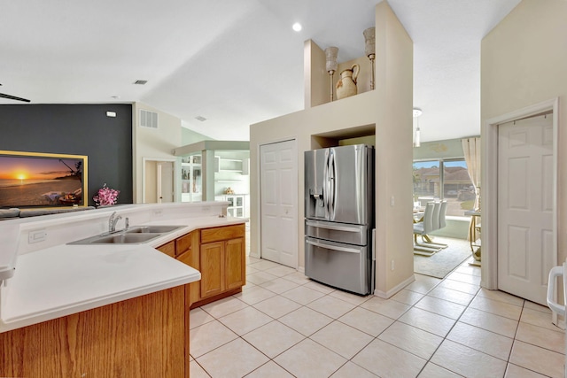 1985 SW Beard St, Port Saint Lucie, FL 34953 - kitchen featuring stainless steel refrigerator with ice dispenser, a sink, light tile patterned flooring, vaulted ceiling, and light countertops