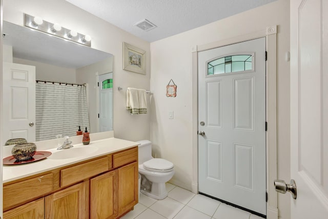 1985 SW Beard St, Port Saint Lucie, FL 34953 - full bathroom with tile patterned floors, toilet, vanity, curtained shower, and a textured ceiling