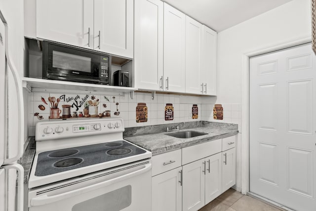 kitchen featuring white electric stove, black microwave, a sink, and white cabinets