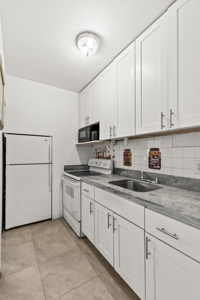 kitchen with white appliances, a sink, backsplash, and white cabinets