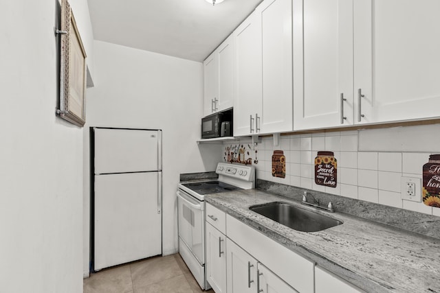 kitchen featuring white appliances, a sink, white cabinetry, tasteful backsplash, and light tile patterned floors