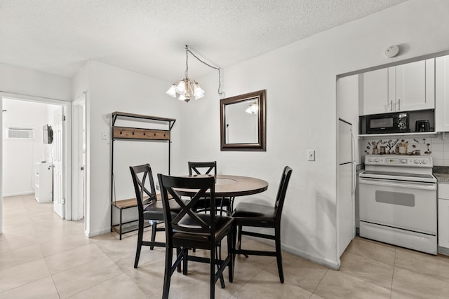 dining space with a textured ceiling, baseboards, light tile patterned floors, and a chandelier