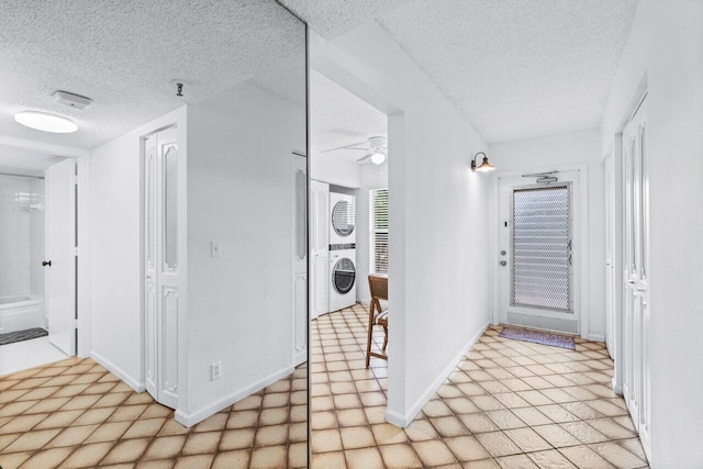 14623 Bonaire Blvd Unit 405, Delray Beach, FL 33446 - corridor with a textured ceiling, estacked washer and dryer, and baseboards