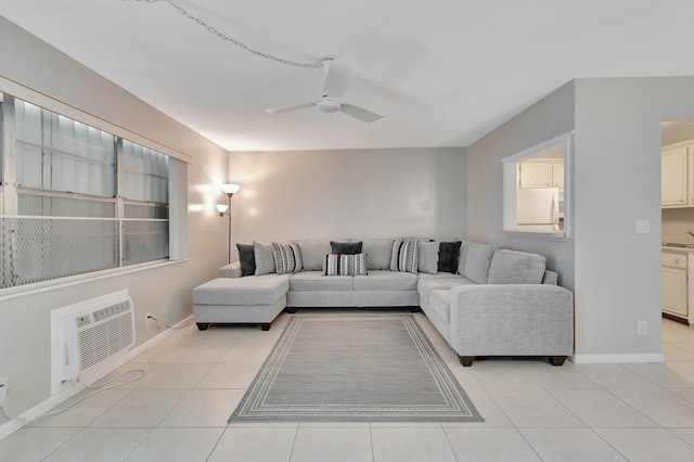 living area with a ceiling fan, light tile patterned floors, a wall mounted air conditioner, and baseboards