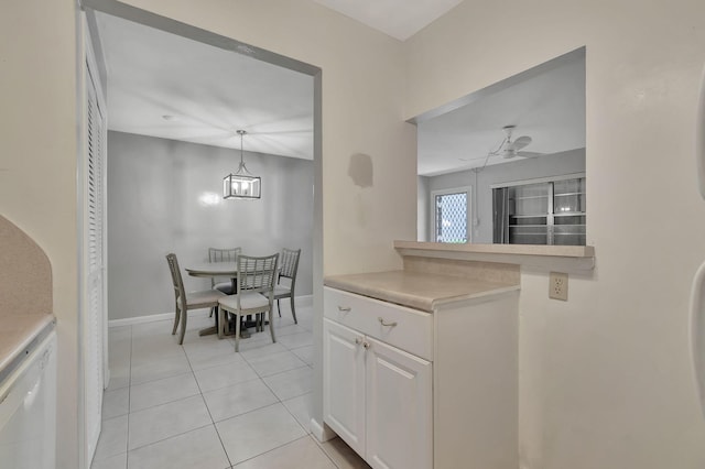 kitchen featuring white cabinetry, white dishwasher, light countertops, light tile patterned floors, and a ceiling fan