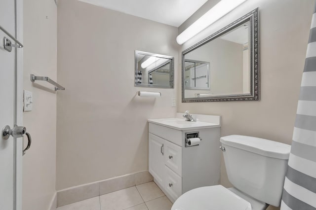 bathroom with toilet, tile patterned flooring, vanity, and baseboards