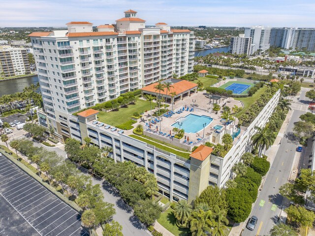 bird's eye view of a pool area, a nearby body of water, and apartment complex