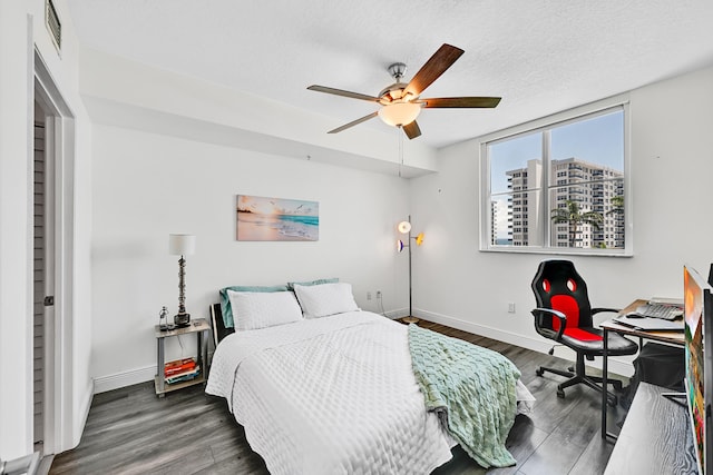 bedroom with wood finished floors, baseboards, ceiling fan, and a textured ceiling