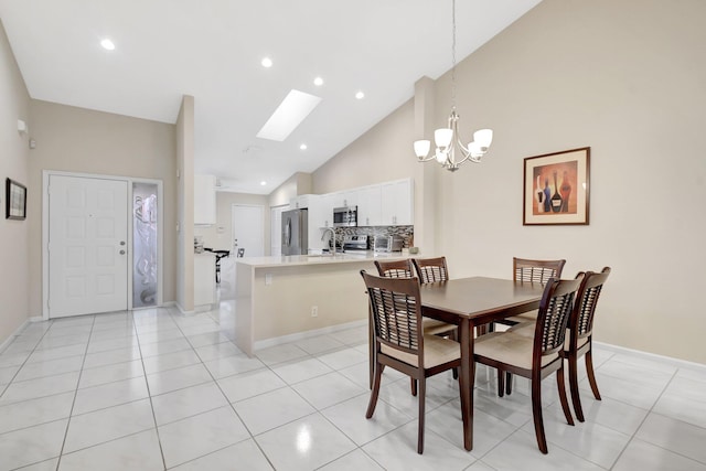 dining space featuring a chandelier, a skylight, high vaulted ceiling, light tile patterned flooring, and recessed lighting