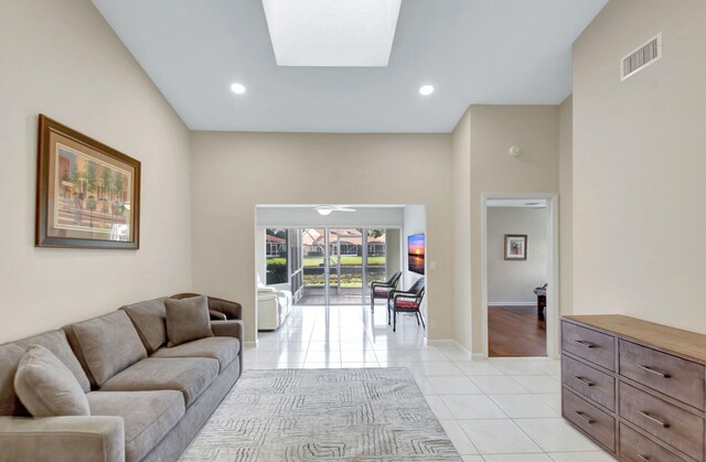 living room with light tile patterned floors, baseboards, recessed lighting, and a skylight