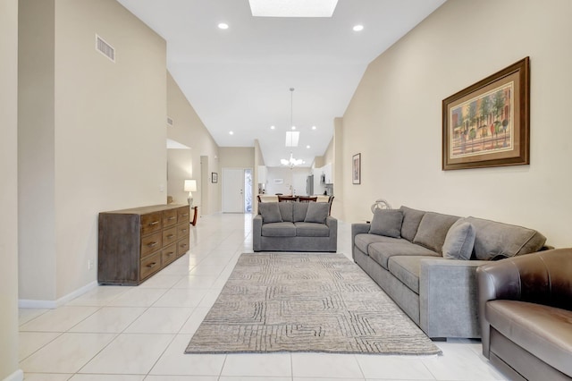 living room with a chandelier, lofted ceiling, light tile patterned floors, a skylight, and recessed lighting