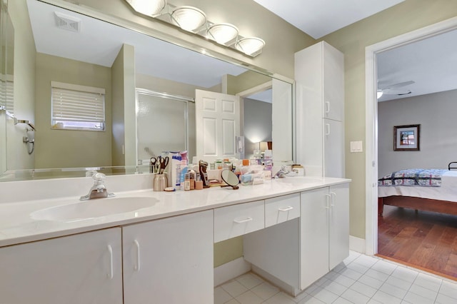 bathroom with ensuite bathroom, tile patterned flooring, a shower stall, double vanity, and ceiling fan