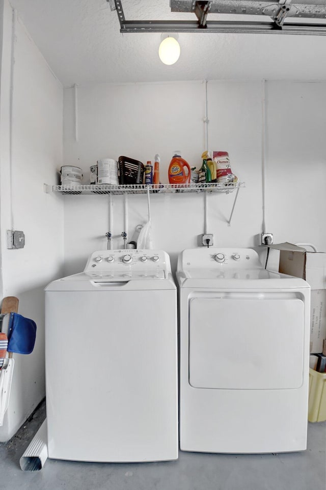 clothes washing area with separate washer and dryer and a textured ceiling