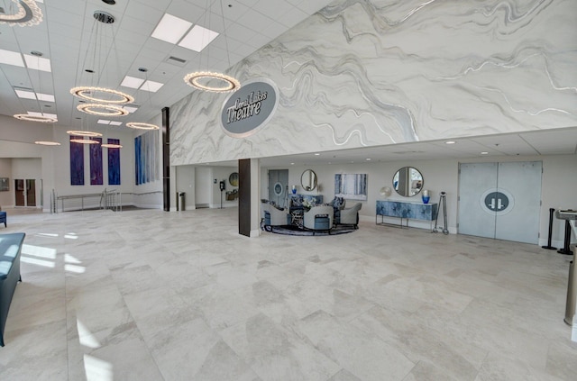 lobby featuring a towering ceiling and a paneled ceiling