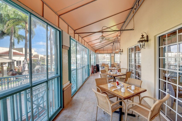 sunroom / solarium featuring ceiling fan, high vaulted ceiling, and outdoor dining space