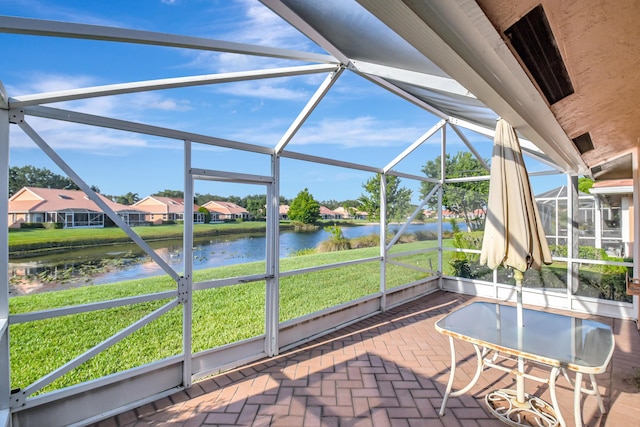 sunroom with a water view and a residential view