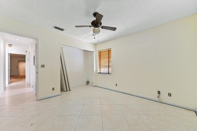 6120 Kings Gate Cir, Delray Beach, FL 33484 - unfurnished bedroom with a textured ceiling, a closet, baseboards, and light tile patterned flooring