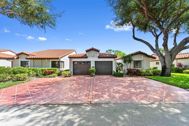 6120 Kings Gate Cir, Delray Beach, FL 33484 - mediterranean / spanish-style home with stucco siding, a tiled roof, a garage, and driveway