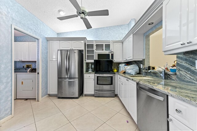 6120 Kings Gate Cir, Delray Beach, FL 33484 - kitchen with stainless steel appliances, a sink, washer and dryer, ceiling fan, and a textured ceiling