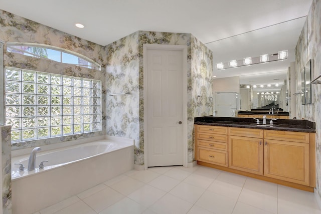 bathroom with a garden tub, plenty of natural light, vanity, wallpapered walls, and tile patterned floors