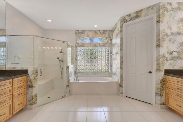 full bathroom featuring vanity, wallpapered walls, a bath, a stall shower, and tile patterned flooring