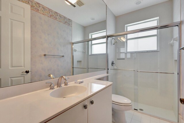 bathroom featuring toilet, a stall shower, vanity, tile patterned floors, and wallpapered walls