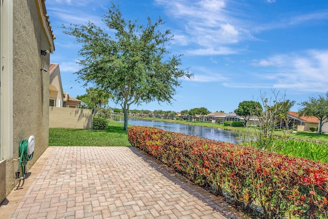 view of patio / terrace with a water view, a residential view, and fence