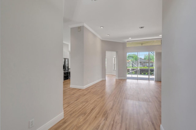 spare room featuring baseboards, crown molding, light wood-type flooring, and recessed lighting