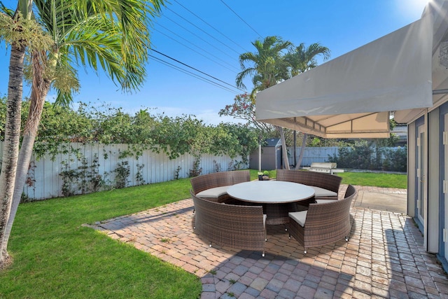 2230 NE 62nd St, Fort Lauderdale, FL 33308 - view of patio / terrace featuring a storage unit, outdoor dining area, and an outbuilding