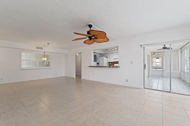 unfurnished living room with ceiling fan and light tile patterned floors
