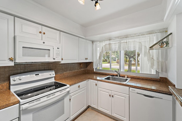 kitchen featuring white appliances, a sink, white cabinetry, decorative backsplash, and dark countertops