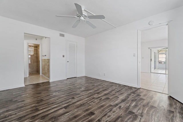 unfurnished bedroom with wood finished floors, ceiling fan, ensuite bathroom, and a closet