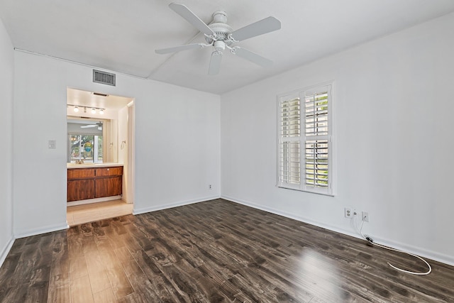 unfurnished room with wood finished floors, a ceiling fan, and baseboards