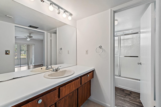 full bathroom with vanity, a ceiling fan, combined bath / shower with glass door, and baseboards