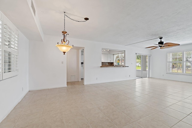 unfurnished living room with light tile patterned floors, ceiling fan, and baseboards