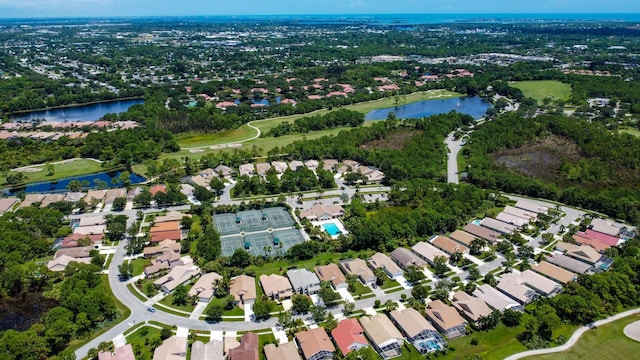 aerial view of property and surrounding area with a nearby body of water and nearby suburban area