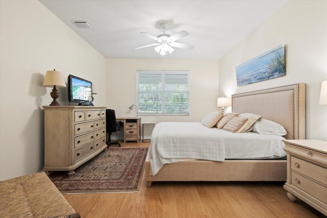 bedroom featuring wood finished floors, a desk, and a ceiling fan