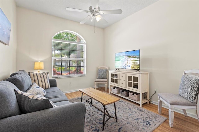 living room featuring wood finished floors, ceiling fan, and baseboards