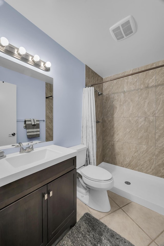 full bathroom with tile patterned flooring, a tile shower, vanity, and toilet